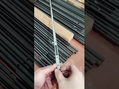 Ένας άνδρας δείχνει ένα μικρό εξαρτήμα από σωλήνα χάλυβα άνθρακα